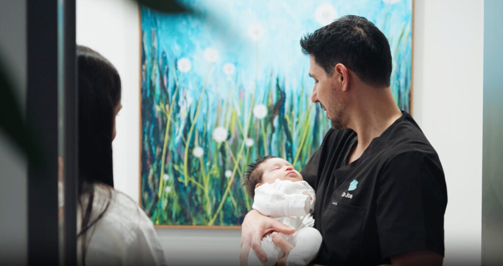 Dr J holding a new born baby